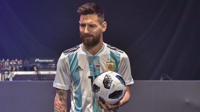 TOPSHOT - Barcelona and Argentina forward Lionel Messi poses with the official match ball for the 2018 World Cup football tournament, named 'Telstar 18', during its unveiling ceremony in Moscow on November 9, 2017. / AFP PHOTO / Mladen ANTONOV