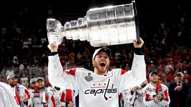 LAS VEGAS, NV - JUNE 07: John Carlson #74 of the Washington Capitals hoists the Stanley Cup after his team defeated the Vegas Golden Knights 4-3 in Game Five of the 2018 NHL Stanley Cup Final at T-Mobile Arena on June 7, 2018 in Las Vegas, Nevada.