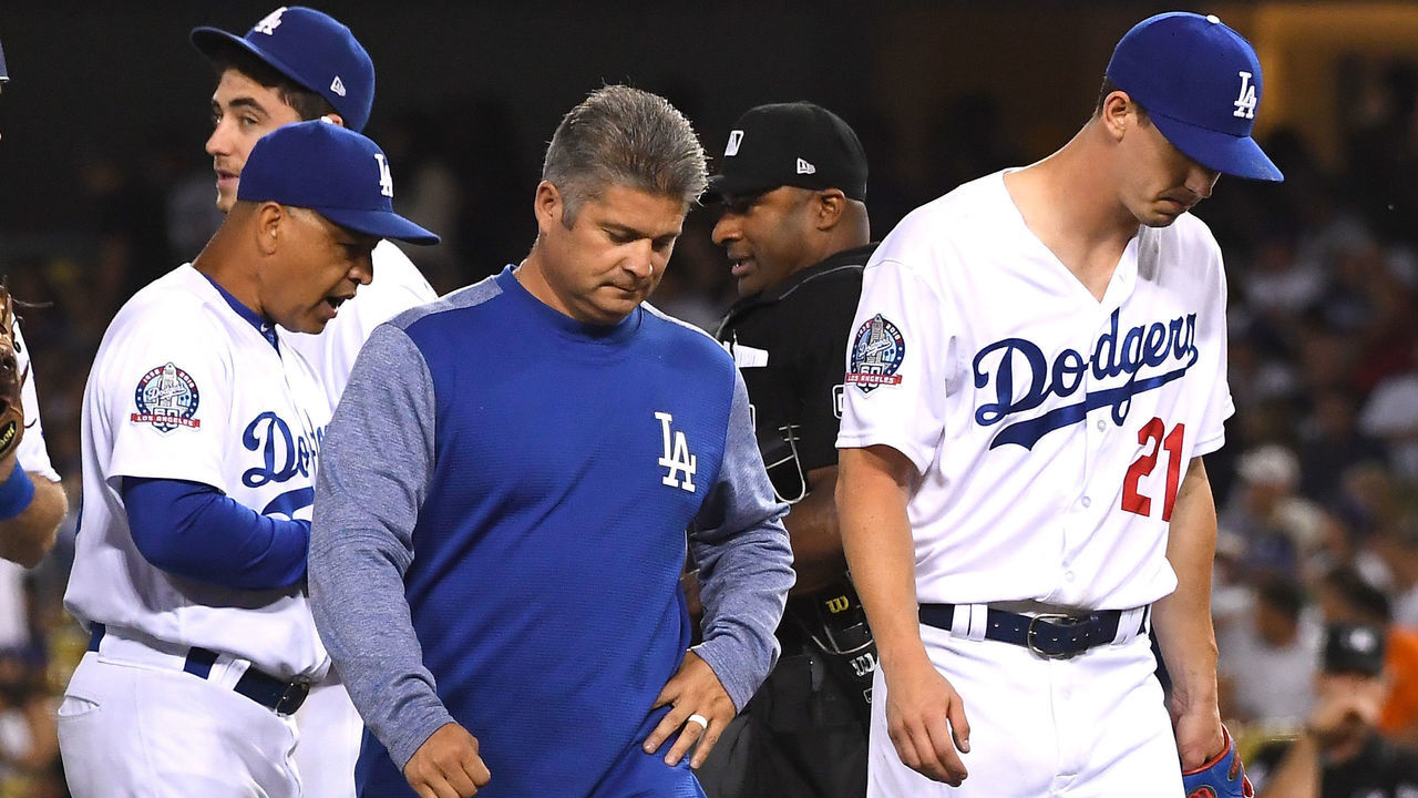 LOS ANGELES, CA - JUNE 08: Heat athletic trainer Neil Rampe walks off the field with starting pitcher Walker Buehler #21 of the Los Angeles Dodgers as he leaves because of an injury in the fifth inning of the game against the Atlanta Braves at Dodger Stadium on June 8, 2018 in Los Angeles, California.