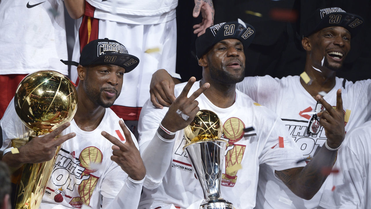 Dwyane Wade (L), LeBron James (C) and Chris Bosh (R) of the Miami Heat celebrate winning Game 7 of the NBA Finals at the American Airlines Arena June 20, 2013 in Miami, Florida. The Miami Heat, led by NBA Most Valuable Player LeBron James, won the NBA Finals for the second consecutive year by defeating the San Antonio Spurs 95-88 in game seven of the championship series. AFP PHOTO / Brendan SMIALOWSKI