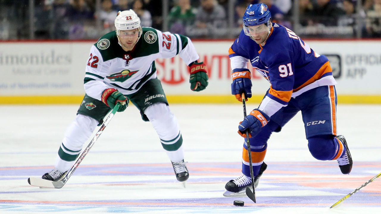 NEW YORK, NY - FEBRUARY 19: Nino Niederreiter #22 of the Minnesota Wild chases the puck against John Tavares #91 of the New York Islanders in the second period during their game at Barclays Center on February 19, 2018 in the Brooklyn borough of New York City.