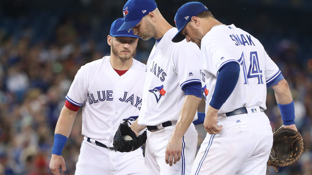 TORONTO, ON - AUGUST 8: J.A. Happ #33 of the Toronto Blue Jays waits for manager John Gibbons #5 moments before beig relieved as Josh Donaldson #20 and Justin Smoak #14 congratulate him in the sixth inning during MLB game action against the New York Yankees at Rogers Centre on August 8, 2017 in Toronto, Canada.