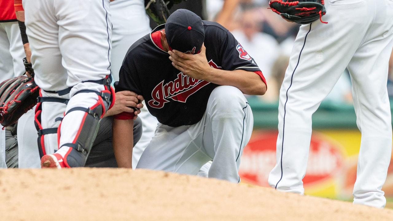 CLEVELAND, OH - JUNE 16: Starting pitcher Carlos Carrasco #59 of the Cleveland Indians gets attention from a trainer after being hit by a line drive off the bat of Joe Mauer #7 of the Minnesota Twins during the second inning at Progressive Field on June 16, 2018 in Cleveland, Ohio.