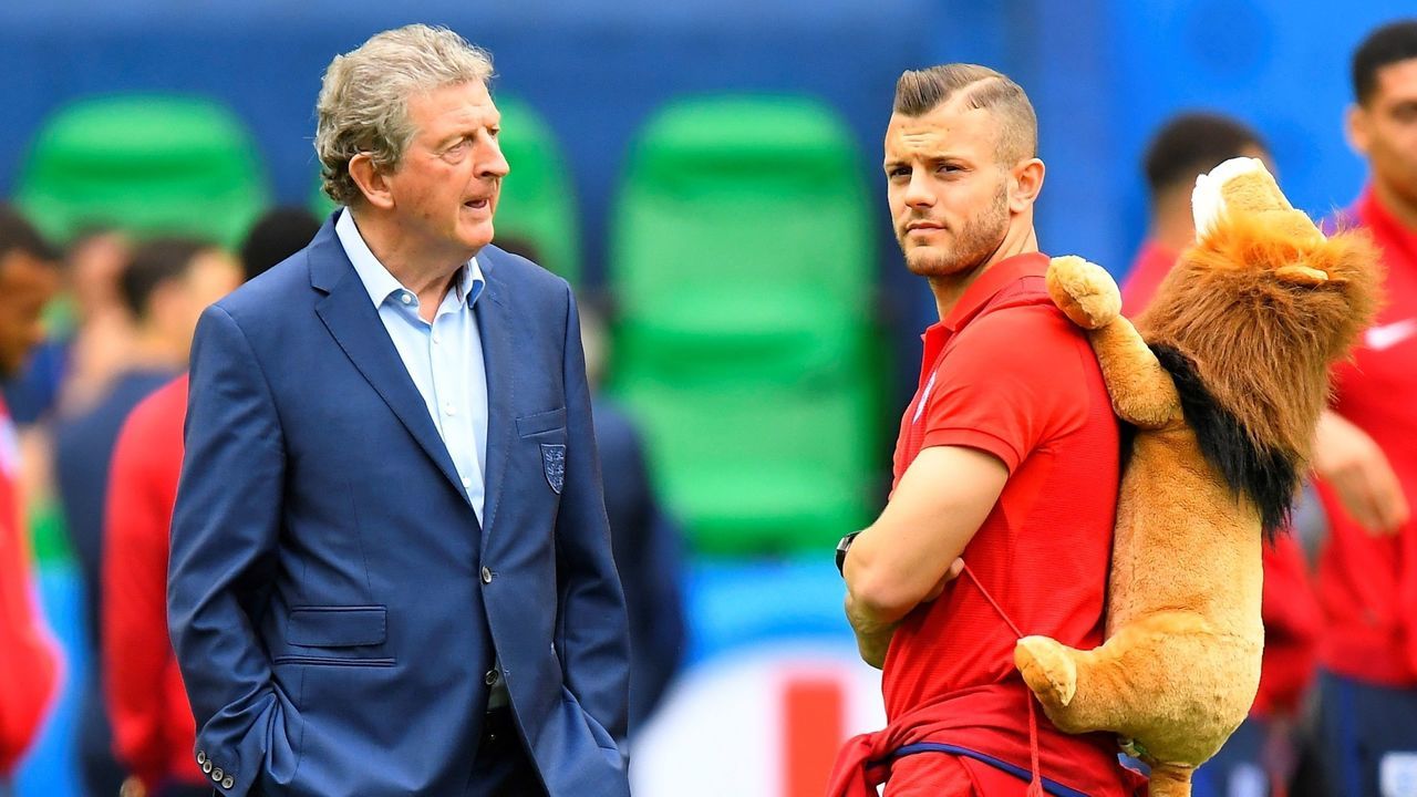 England's head coach Roy Hodgson (L) speaks to midfielder Jack Wilshere while they check a pitch on the eve of their match against Slovakia in Saint Etienne on June 19, 2016, during the the Euro 2016 football tournament. / AFP / JOE KLAMAR