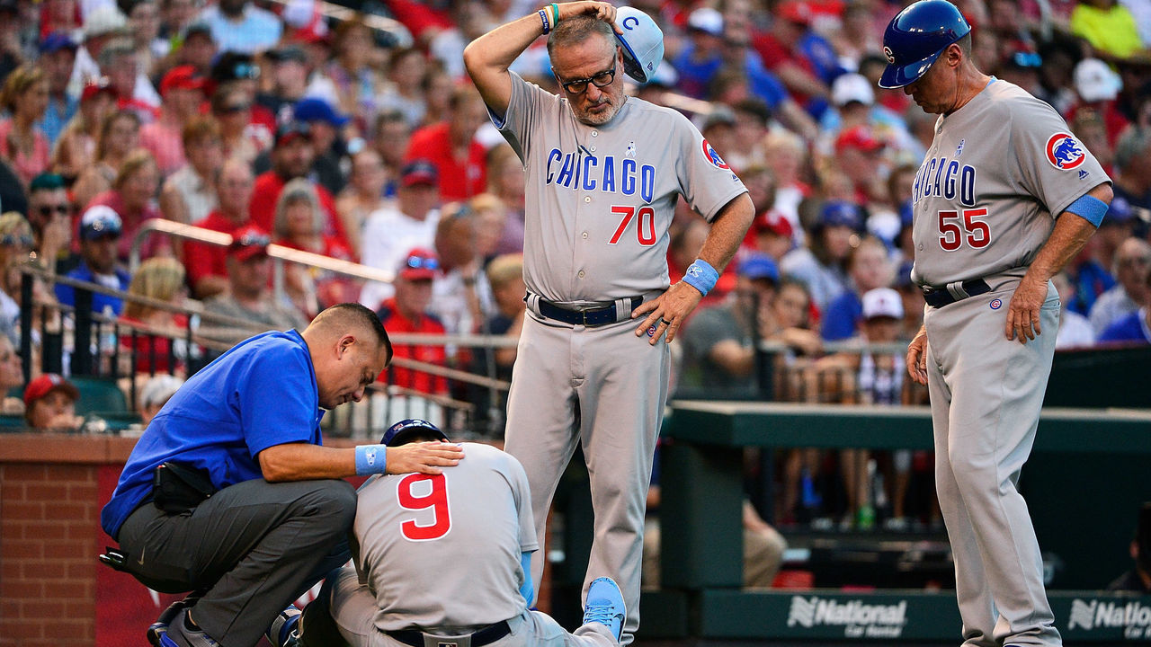 ST LOUIS, MO - JUNE 17: Joe Maddon #70 and third base coach Brian Butterfield #55 of the Chicago Cubs look on as Javier Baez #9 is checked out by a trainer after he was hit by a pitch in the elbow by Jack Flaherty #32 of the St. Louis Cardinals during the third inning at Busch Stadium on June 17, 2018 in St Louis, Missouri.