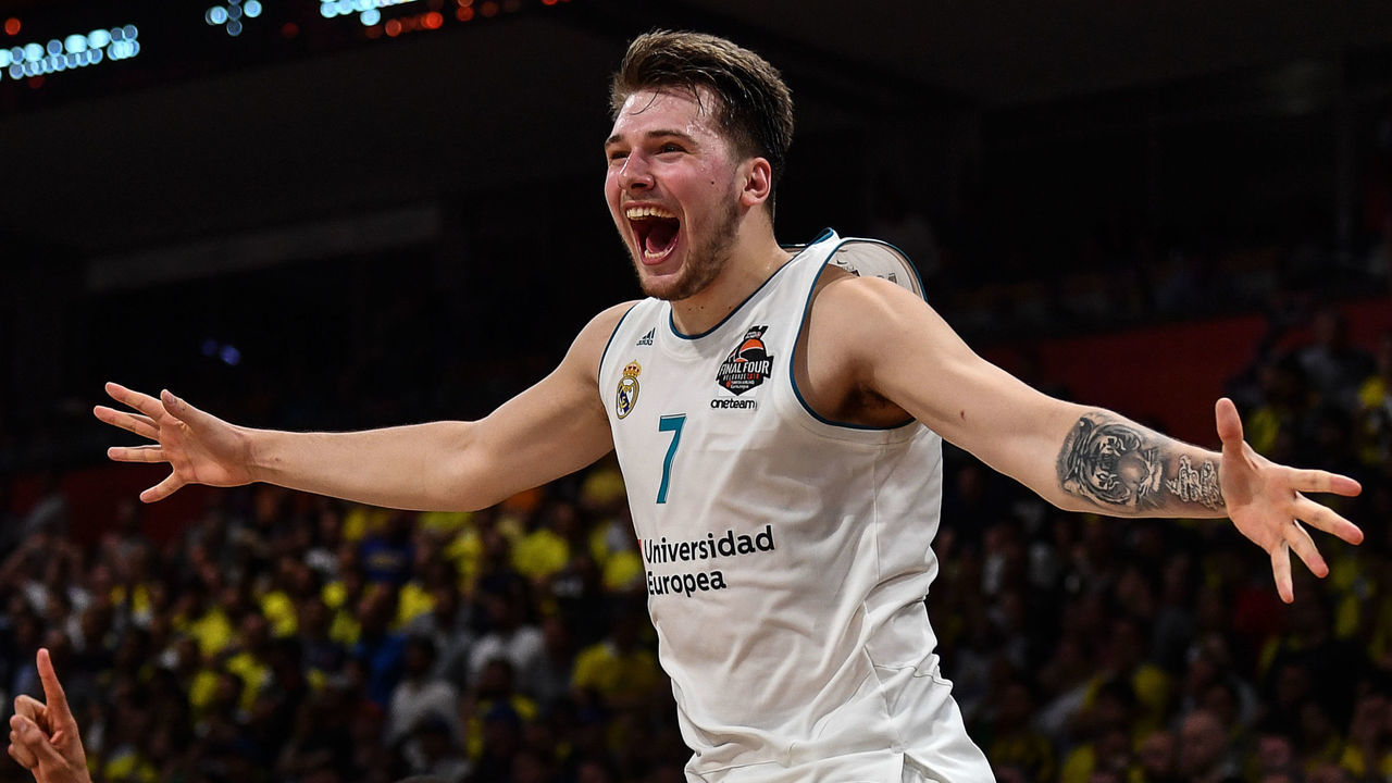 Real Madrid's Slovenian Luka Doncic (C-7) jumps over the barrier as the team celebrates their 85-80 win over Fenerbahce in the Euroleague Final Four finals basketball match between Real Madrid and Fenerbahce Dogus Istanbul at The Stark Arena in Belgrade on May 20, 2018.