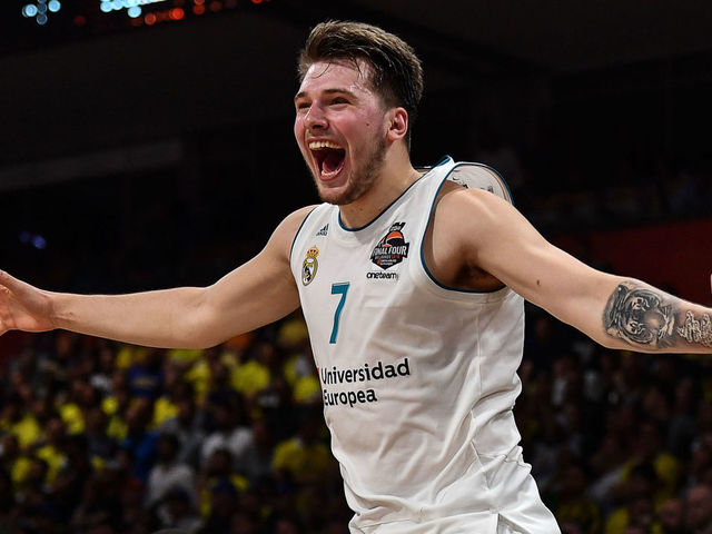 Real Madrid's Slovenian Luka Doncic (C-7) jumps over the barrier as the team celebrates their 85-80 win over Fenerbahce in the Euroleague Final Four finals basketball match between Real Madrid and Fenerbahce Dogus Istanbul at The Stark Arena in Belgrade on May 20, 2018.