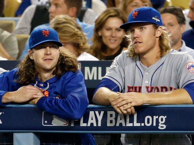LOS ANGELES, CA - OCTOBER 15: Jacob deGrom #48 and Noah Syndergaard #34 of the New York Mets watch from the dugout in the eighth inning against the Los Angeles Dodgers in game five of the National League Division Series at Dodger Stadium on October 15, 2015 in Los Angeles, California.