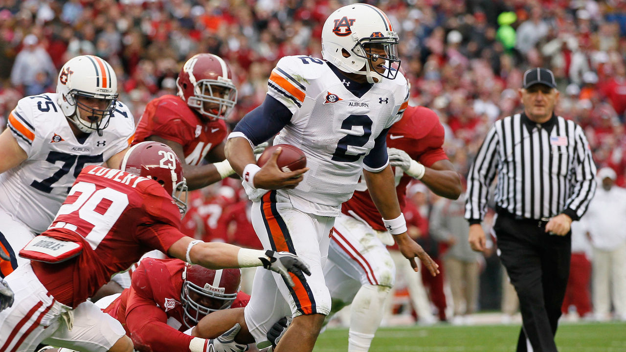 TUSCALOOSA, AL - NOVEMBER 26: Quarterback Cam Newton #2 of the Auburn Tigers rushes upfield away from Will Lowery #29 and Marcell Dareus #57 of the Alabama Crimson Tide at Bryant-Denny Stadium on November 26, 2010 in Tuscaloosa, Alabama.