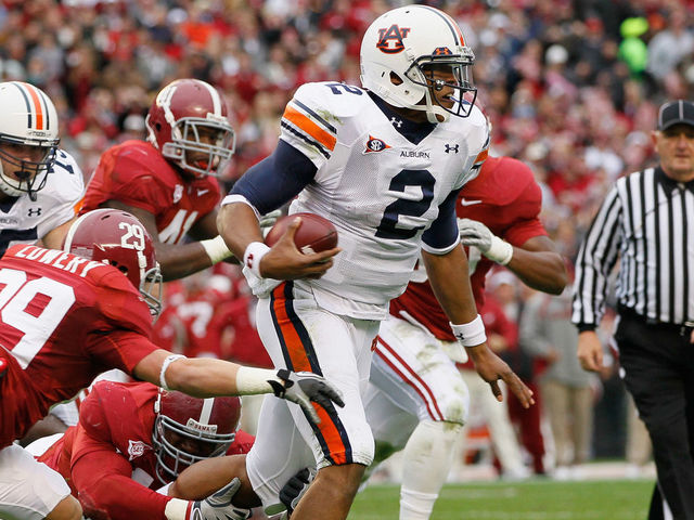 TUSCALOOSA, AL - NOVEMBER 26: Quarterback Cam Newton #2 of the Auburn Tigers rushes upfield away from Will Lowery #29 and Marcell Dareus #57 of the Alabama Crimson Tide at Bryant-Denny Stadium on November 26, 2010 in Tuscaloosa, Alabama.