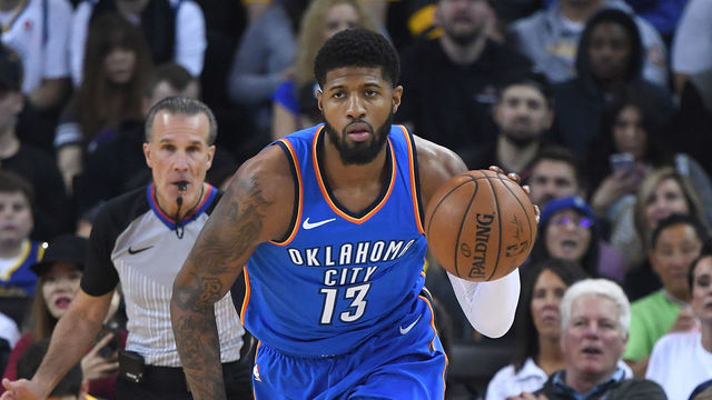 OAKLAND, CA - FEBRUARY 06: Paul George #13 of the Oklahoma City Thunder dribbles the ball up court against the Golden State Warriors during the first half of their NBA basketball game at ORACLE Arena on February 6, 2018 in Oakland, California.