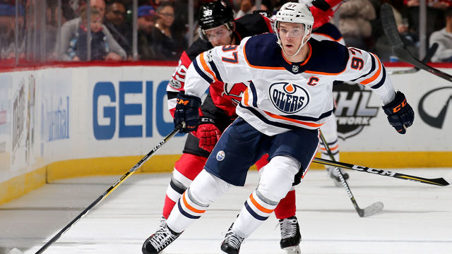NEWARK, NJ - NOVEMBER 09: Connor McDavid #97 of the Edmonton Oilers takes the puck as Brian Gibbons #39 of the New Jersey Devils defends on November 9, 2017 at Prudential Center in Newark, New Jersey.