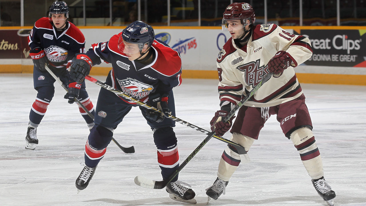 PETERBOROUGH, ON - OCTOBER 26: Blade Jenkins #19 of the Saginaw Spirit skates against Adam Timleck #18 of the Peterborough Petes in an OHL game at the Peterborough Memorial Centre on October 26, 2017 in Peterborough, Ontario, Canada.