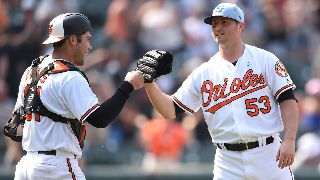 BALTIMORE, MD - JUNE 17: Zach Britton #53 of the Baltimore Orioles celebrates a win with Austin Wynns #61 after a baseball game against the Miami Marlins at Oriole Park at Camden Yards on June 17, 2018 in Baltimore, Maryland.