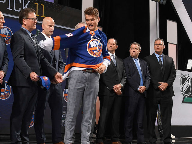 DALLAS, TX - JUNE 22: Oliver Wahlstrom puts on a New York Islanders jersey after being selected eleventh overall by the New York Islanders during the first round of the 2018 NHL Draft at American Airlines Center on June 22, 2018 in Dallas, Texas.