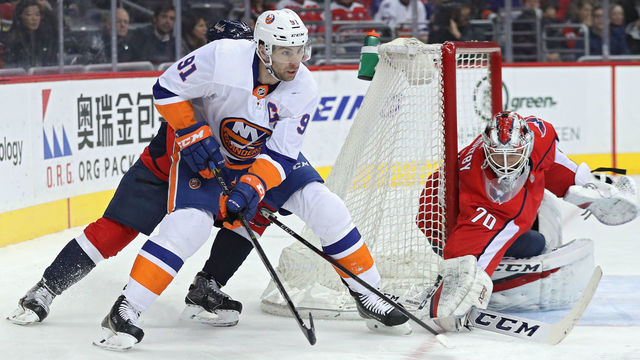 WASHINGTON, DC - MARCH 16: John Tavares #91 of the New York Islanders skates in front og goalie Braden Holtby #70 of the Washington Capitals during the first period at Capital One Arena on March 16, 2018 in Washington, DC.