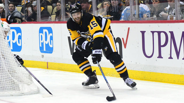 PITTSBURGH, PA - DECEMBER 23: Riley Sheahan #15 of the Pittsburgh Penguins reaches for the puck against the Anaheim Ducks at PPG PAINTS Arena on December 23, 2017 in Pittsburgh, Pennsylvania.