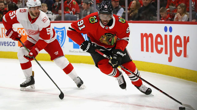 CHICAGO, IL - JANUARY 14: Anthony Duclair #91 of the Chicago Blackhawks looks to pass next to Frans Nielsen #51 of the Detroit Red Wings at the United Center on January 14, 2018 in Chicago, Illinois.