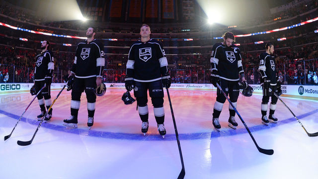 LOS ANGELES, CA - MARCH 15: Drew Doughty #8, Derek Forbort #24, Dustin Brown #23, Anze Kopitar #11, and Alex Iafallo #19 of the Los Angeles Kings stand for the National Anthem before a game against the Detroit Red Wings at STAPLES Center on March 15, 2018 in Los Angeles, California.