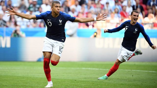 TOPSHOT - France's forward Kylian Mbappe (L) celebrates past France's forward Antoine Griezmann after scoring their fourth goal during the Russia 2018 World Cup round of 16 football match between France and Argentina at the Kazan Arena in Kazan on June 30, 2018.