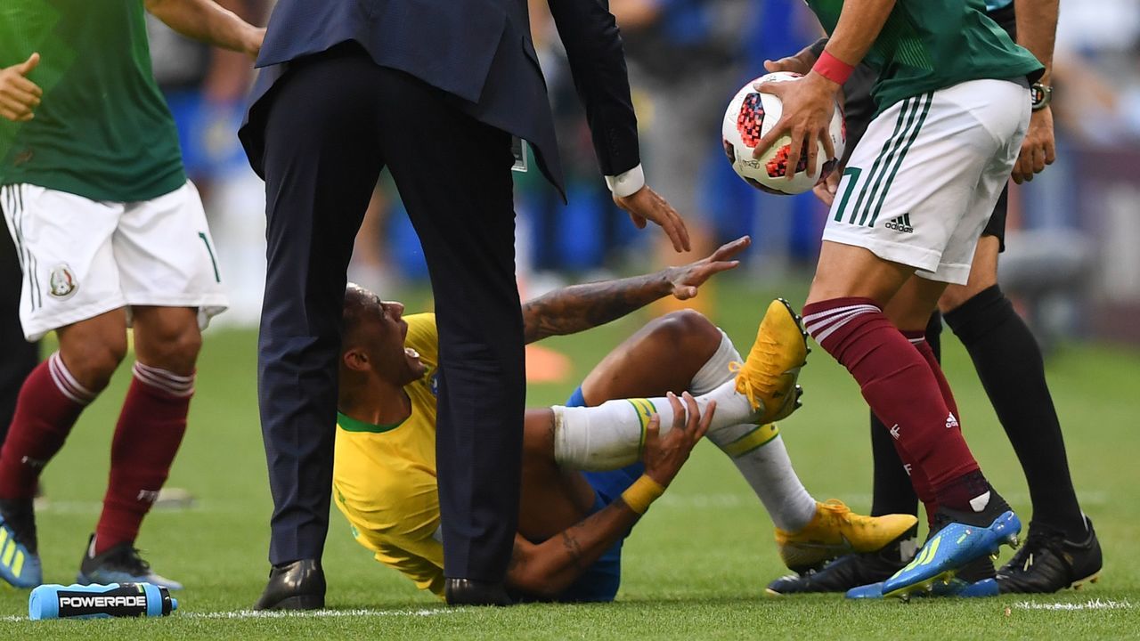 Brazil's forward Neymar (bottom C) reacts on the ground after resulting injured next to Mexico's defender Miguel Layun (R) holding the ball during the Russia 2018 World Cup round of 16 football match between Brazil and Mexico at the Samara Arena in Samara on July 2, 2018.