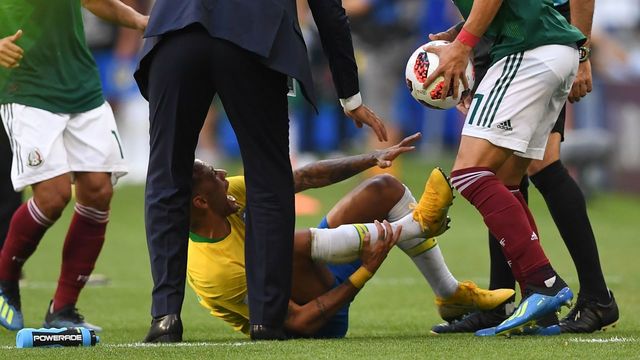 Brazil's forward Neymar (bottom C) reacts on the ground after resulting injured next to Mexico's defender Miguel Layun (R) holding the ball during the Russia 2018 World Cup round of 16 football match between Brazil and Mexico at the Samara Arena in Samara on July 2, 2018.