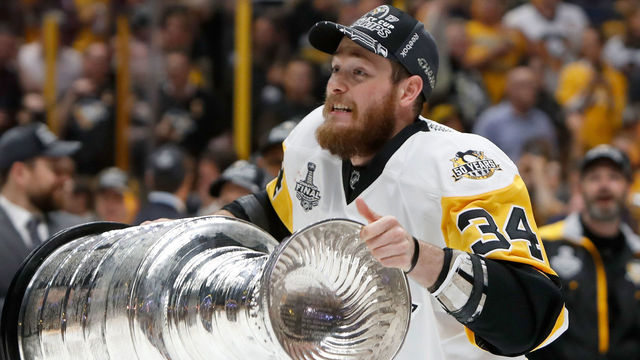 NASHVILLE, TN - JUNE 11: Tom Kuhnhackl #34 of the Pittsburgh Penguins celebrates with the Stanley Cup trophy after defeating the Nashville Predators 2-0 in Game Six of the 2017 NHL Stanley Cup Final at the Bridgestone Arena on June 11, 2017 in Nashville, Tennessee.