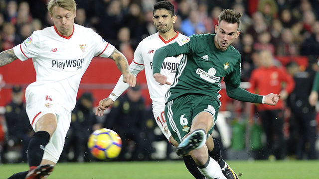 Real Betis' Spanish midfielder Fabian Ruiz (R) scores a goal during the Spanish league football match between Sevilla and Real Betis at the Sanchez Pizjuan stadium in Sevilla on January 6, 2018. / AFP PHOTO / CRISTINA QUICLER