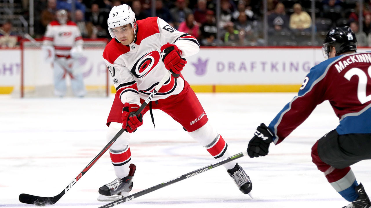DENVER, CO - NOVEMBER 02: Trevor van Riemsdyk #57 of the Carolina Hurricanes advances the puck against Nathan MacKinnon #29 of the Colorado Avalanche at the Pepsi Center on November 2, 2017 in Denver, Colorado.
