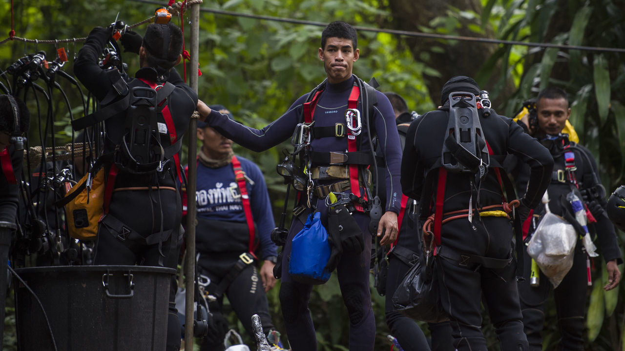 Thai divers carry supplies as rescue operations continue for 12 boys and their coach trapped at Tham Luang cave at Khun Nam Nang Non Forest Park in the Mae Sai district of Chiang Rai province on July 5, 2018. - Thai rescuers vowed to take a 'no risk' approach to freeing 12 boys and their football coach from a flooded cave, as fresh video emerged on July 4 showing the team in good spirits following their astonishing discovery nine days after going missing.