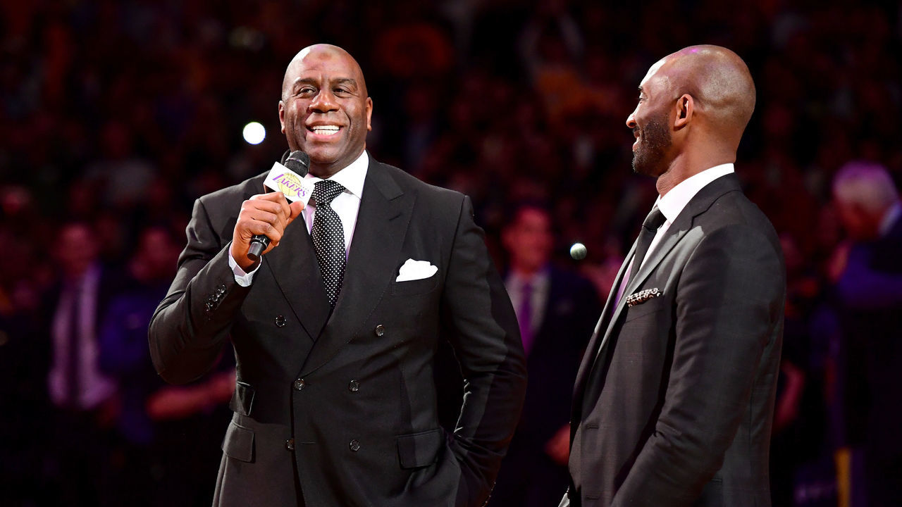 LOS ANGELES, CA - DECEMBER 18: (L-R) Earvin 'Magic' Johnson addresses the crowd before Kobe Bryant has his #8 and #24 Los Angeles Lakers jerseys retired at Staples Center on December 18, 2017 in Los Angeles, California.