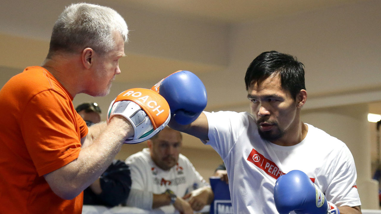Philippine boxer Manny Pacquiao (R) spars with his trainer Freddie Roach during a training session in Brisbane on June 27, 2017 in preparation for his upcoming WBO Welterweight title defence against Australian challenger Jeff Horn. The title bout between Pacquiao and Horn is scheduled to be held on July 2. / AFP PHOTO / Tertius PICKARD / -- IMAGE RESTRICTED TO EDITORIAL USE - STRICTLY NO COMMERCIAL USE --