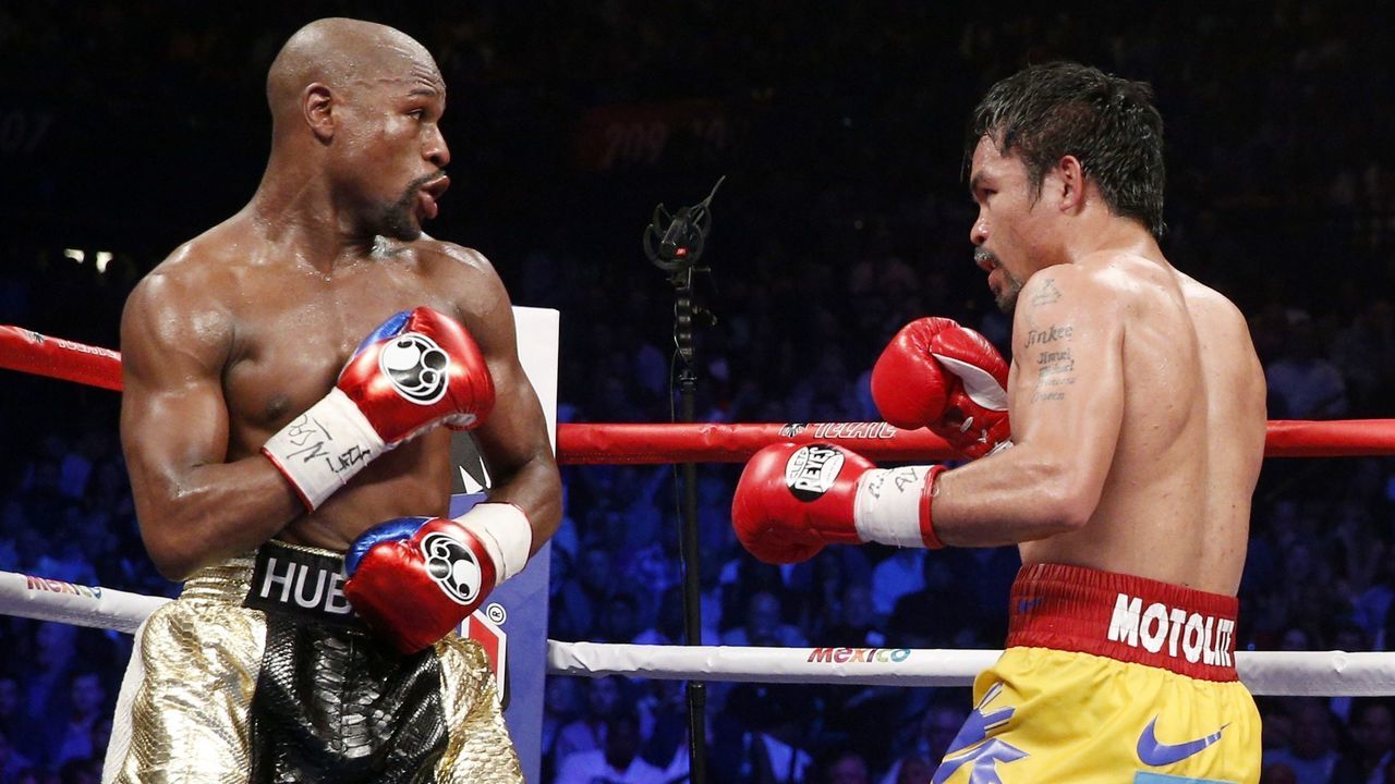 Floyd Mayweather Jr. exchange punches with Manny Pacquiao during their welterweight unification championship bout, May 2, 2015 at MGM Grand Garden Arena in Las Vegas, Nevada. Mayweather defeated Pacquiao by unanimous decision. AFP PHOTO / JOHN GURZINKSI