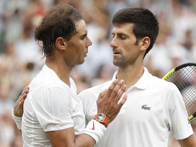 Serbia's Novak Djokovic (R) shakes hands after beating Spain's Rafael Nadal during the continuation of their men's singles semi-final match on the twelfth day of the 2018 Wimbledon Championships at The All England Lawn Tennis Club in Wimbledon, southwest London, on July 14, 2018. - Djokovic won the match 6-4, 3-6, 7-6, 3-6, 10-8.