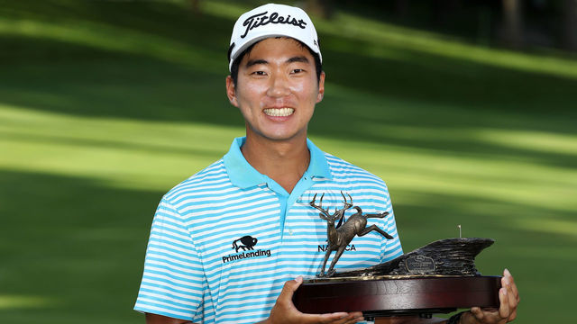SILVIS, IL - JULY 15: Michael Kim celebrates with the trophy after winning the John Deere Classic during the final round at TPC Deere Run on July 15, 2018 in Silvis, Illinois.