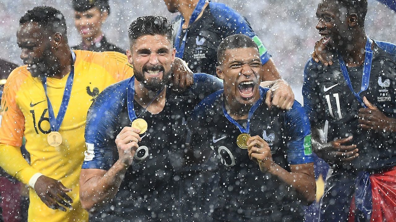 TOPSHOT - (L to R) France's goalkeeper Steve Mandanda, France's forward Olivier Giroud, France's forward Kylian Mbappe and France's forward Ousmane Dembele celebrate during the trophy ceremony at the end of the Russia 2018 World Cup final football match between France and Croatia at the Luzhniki Stadium in Moscow on July 15, 2018.