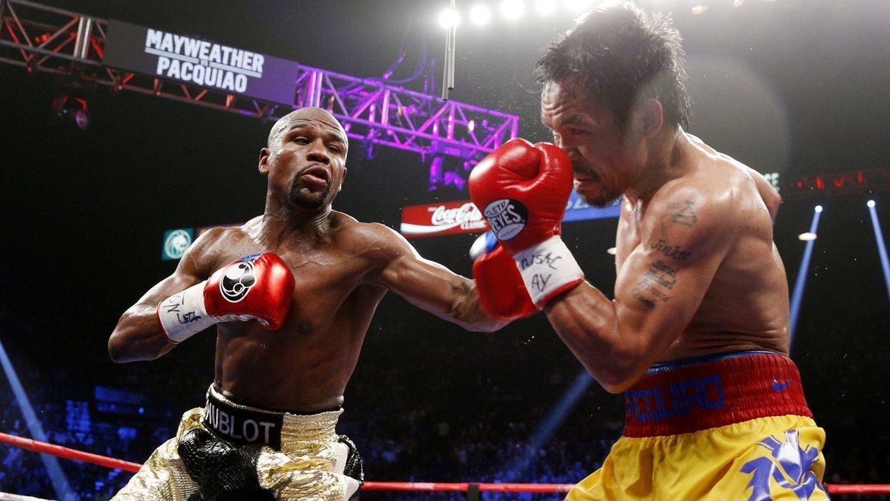 Floyd Mayweather Jr. exchange punches with Manny Pacquiao during their welterweight unification championship bout, May 2, 2015 at MGM Grand Garden Arena in Las Vegas, Nevada. Mayweather defeated Pacquiao by unanimous decision. AFP PHOTO / JOHN GURZINKSI