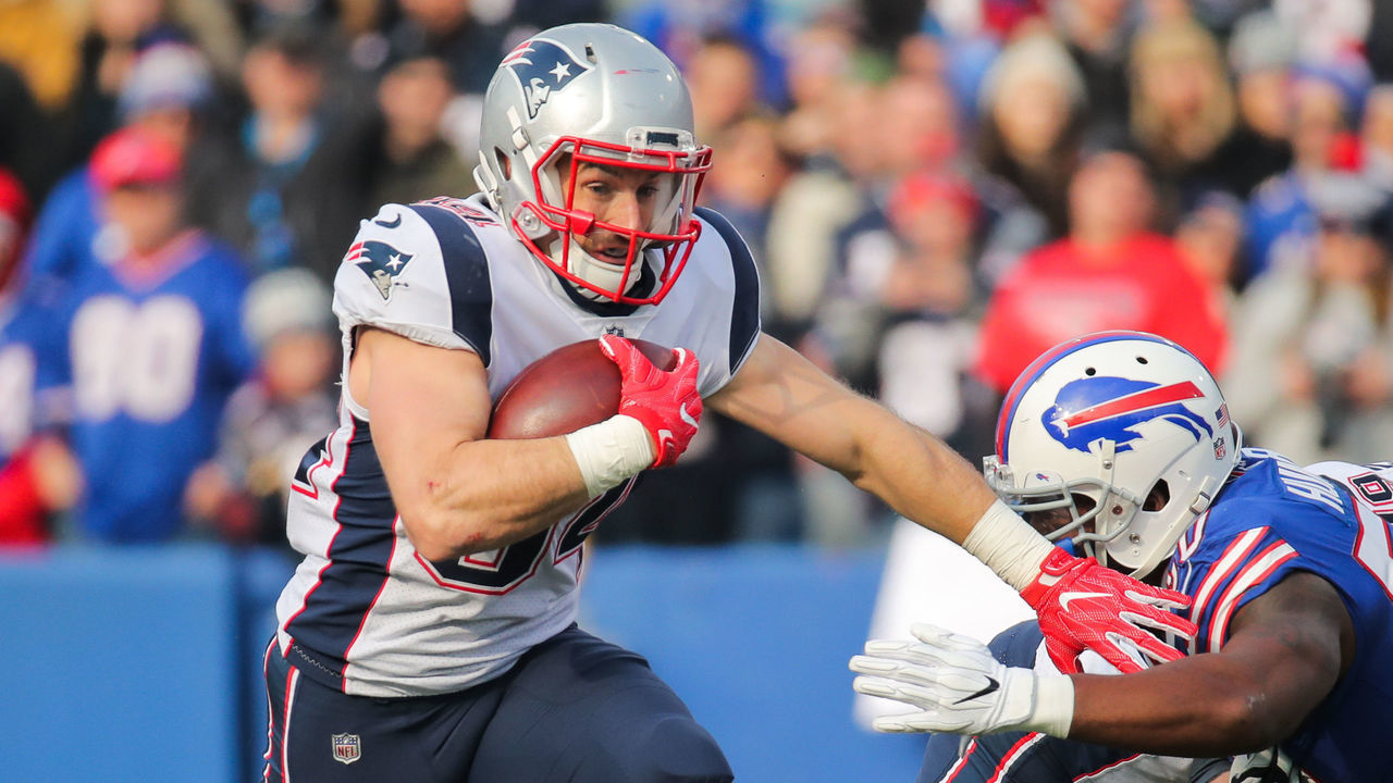 ORCHARD PARK, NY - DECEMBER 3: Rex Burkhead #34 of the New England Patriots runs the ball as Jerry Hughes #55 of the Buffalo Bills attempts to tackle him during the first quarter on December 3, 2017 at New Era Field in Orchard Park, New York.