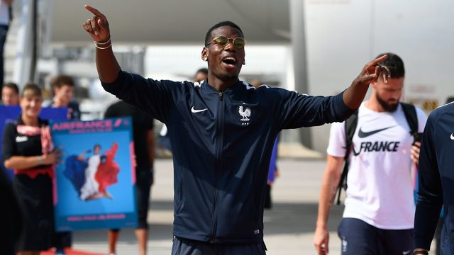 France's midfielder Paul Pogba celebrates with teammates after disembarking from the plane upon their arrival at the Roissy-Charles de Gaulle airport on the outskirts of Paris, on July 16, 2018 after winning the Russia 2018 World Cup final football match.