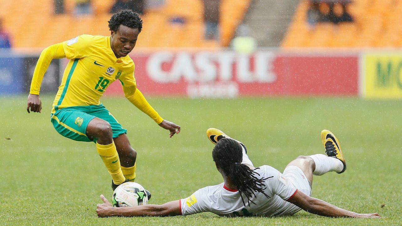 Burkina Faso's Bakary Kone (R) tackles South Africa's Percy Tau during the Fifa World Cup 2018 qualifying football match at Soccer City stadium on October 7, 2017 in Johannesburg. / AFP PHOTO / PHILL MAGAKOE
