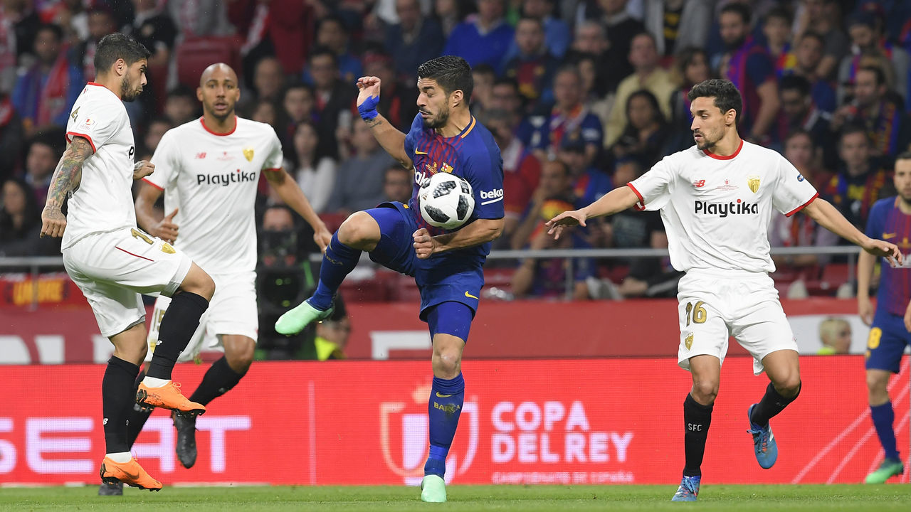 Barcelona's Uruguayan forward Luis Suarez (C) vies with Sevilla's Argentinian midfielder Ever Banega, Sevilla's French midfielder Steven N'Zonzi and Sevilla's Spanish midfielder Jesus Navas during the Spanish Copa del Rey (King's Cup) final football match Sevilla FC against FC Barcelona at the Wanda Metropolitano stadium in Madrid on April 21, 2018.