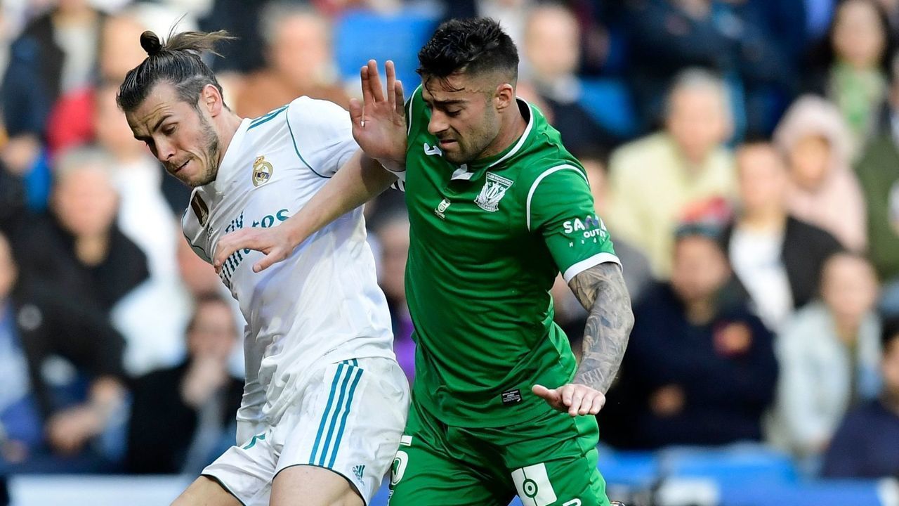 Real Madrid's Welsh forward Gareth Bale (L) challenges Leganes' Spanish midfielder Diego Rico during the Spanish League football match between Real Madrid and Leganes at the Santiago Bernabeu Stadium in Madrid on April 28, 2018.