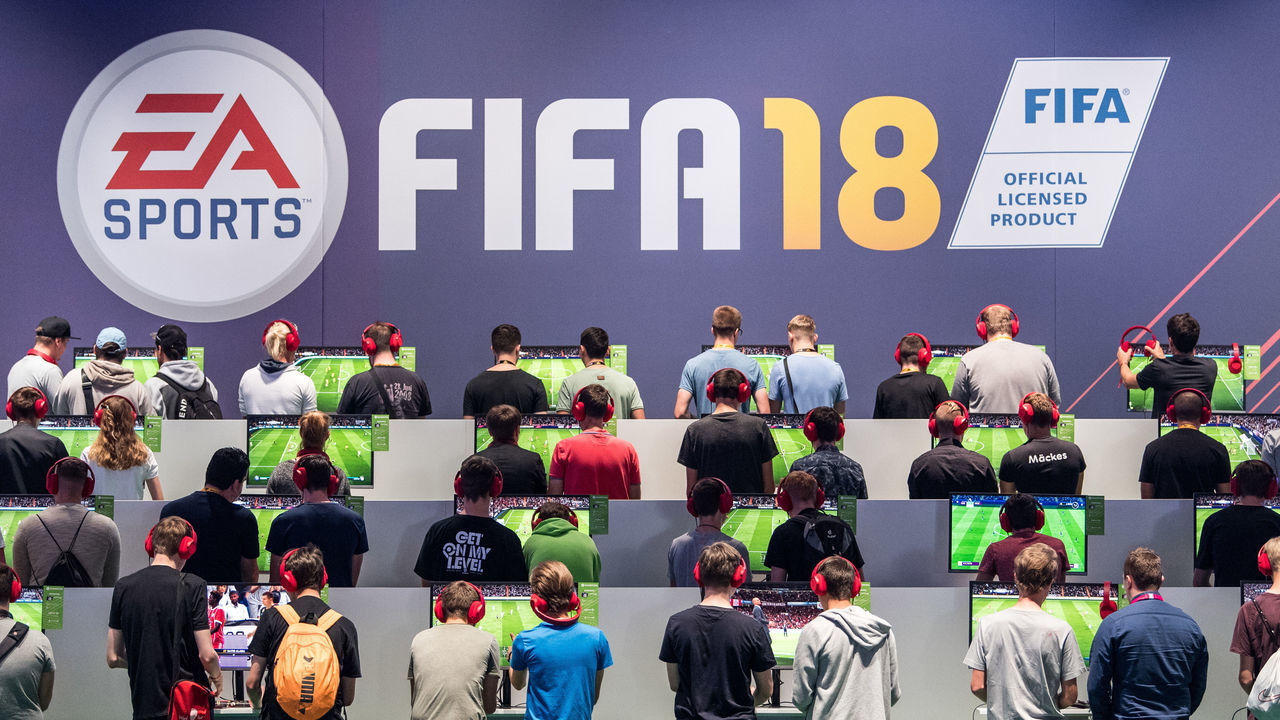 COLOGNE, GERMANY - AUGUST 22: Visitors play the soccer game FIFA18 while visiting the Gamescom 2017 video gaming trade fair on August 22, 2017 in Cologne, Germany. Gamescom is the world's second-largest games fair and attracts over 300,000 visitors. The 2017 fair will be open to the public from August 23-26.
