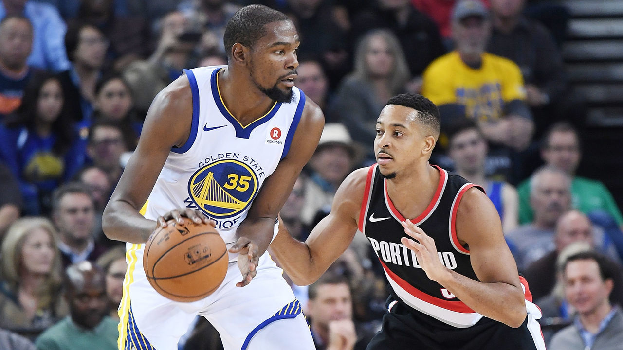 OAKLAND, CA - DECEMBER 11: Kevin Durant #35 of the Golden State Warriors dribbling the ball backs in on CJ McCollum #3 of the Portland Trail Blazers during an NBA basketball game at ORACLE Arena on December 11, 2017 in Oakland, California.