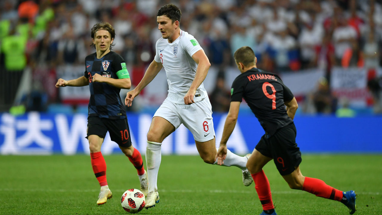 MOSCOW, RUSSIA - JULY 11: Harry Maguire of England runs with the ball under pressure from Luka Modric of Croatia and Andrej Kramaric of Croatia during the 2018 FIFA World Cup Russia Semi Final match between England and Croatia at Luzhniki Stadium on July 11, 2018 in Moscow, Russia.