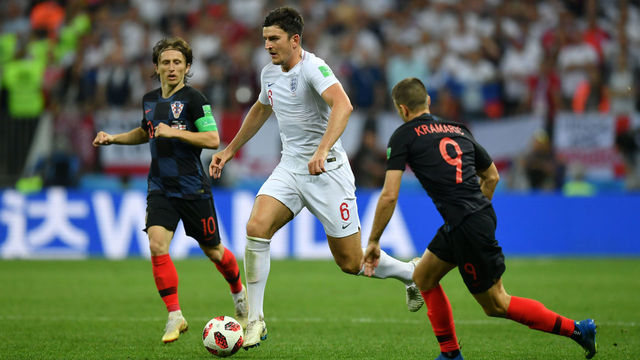 MOSCOW, RUSSIA - JULY 11: Harry Maguire of England runs with the ball under pressure from Luka Modric of Croatia and Andrej Kramaric of Croatia during the 2018 FIFA World Cup Russia Semi Final match between England and Croatia at Luzhniki Stadium on July 11, 2018 in Moscow, Russia.