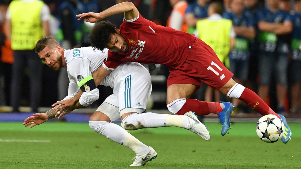 TOPSHOT - Liverpool's Egyptian forward Mohamed Salah (R) falls with Real Madrid's Spanish defender Sergio Ramos leading to Salah being injured during the UEFA Champions League final football match between Liverpool and Real Madrid at the Olympic Stadium in Kiev, Ukraine, on May 26, 2018.