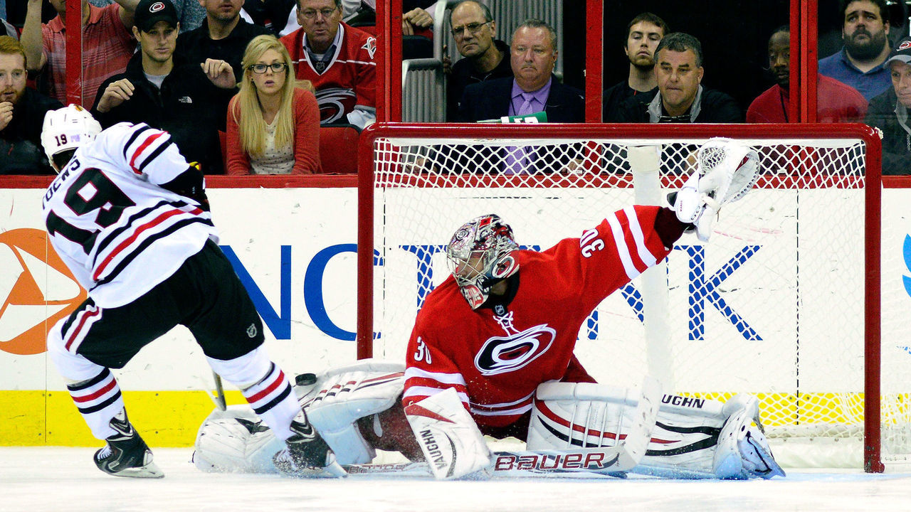 RALEIGH, NC - OCTOBER 15: Cam Ward #30 of the Carolina Hurricanes blocks a shot by Jonathan Toews #19 of the Chicago Blackhawks during a shootout at PNC Arena on October 15, 2013 in Raleigh, North Carolina. The Blackhawks defeated the Hurricanes 3-2 in an overtime shootout.