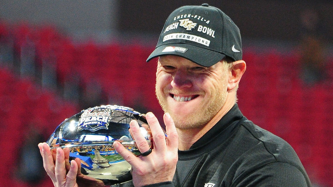 ATLANTA, GA - JANUARY 1: Head Coach Scott Frost of the Central Florida Knights accepts the championship trophy for winning the Chick-fil-A Peach Bowl against the Auburn Tigers on January 1, 2018 in Atlanta, Georgia.