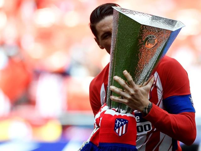 Atletico Madrid's Spanish forward Fernando Torres kisses their Europa League trophy before the Spanish league football match between Club Atletico de Madrid and SD Eibar at the Wanda Metropolitano stadium in Madrid on May 20, 2018.